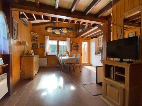 een woonkamer met een televisie en een eetkamer bij Chalet de montaña in Bolquere Pyrenees 2000