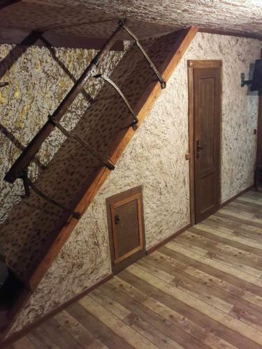 Zimmer im Dachgeschoss mit Holzboden und Tür in der Unterkunft Xrchit (Խրճիթ) in Gjumri