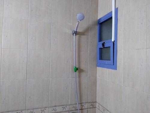 a shower in a bathroom with a blue window at Studio Apartment in Ajman 