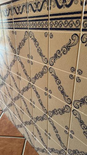 a tiled wall with a design on it at Sunrise Apartment in Caniço