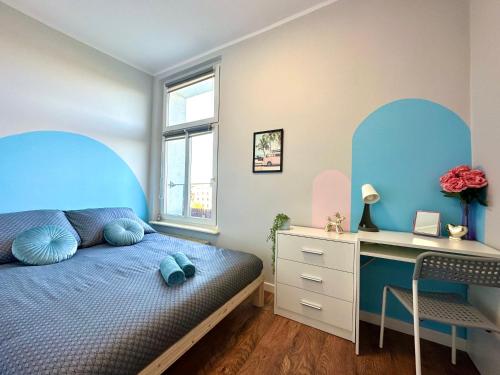 a bedroom with a blue bed and a desk at MMRent Miami Room in Gdańsk