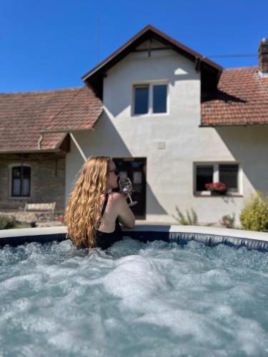 a woman is sitting in a swimming pool at Útulné spaní ve venkovské chaloupce in Podbřezí