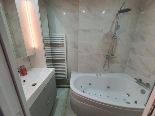 y baño con bañera, aseo y lavamanos. en Appartement meublé de 77 m² Champigny-Sur-Marne, en Champigny-sur-Marne
