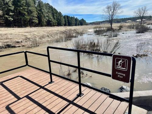 a sign on a wooden boardwalk next to a river at Penthouse Suite at Meadow View! in Show Low