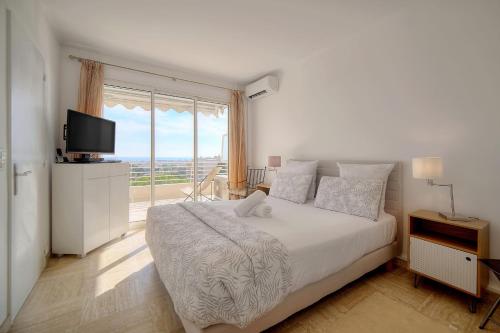 1 dormitorio con cama grande y ventana grande en IMMOGROOM - 1 Bedroom - Terasse - Sea View - AC - Wifi, en Cannes