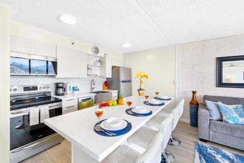 une cuisine blanche avec une table et des chaises blanches dans l'établissement Stylish Unit Near Waikiki Beach with Free Parking!, à Honolulu