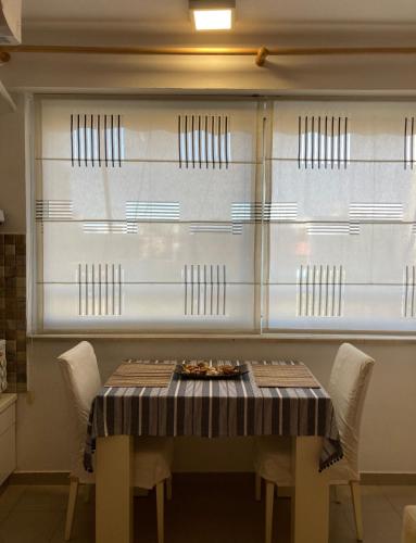 a table and chairs in a kitchen with a window at Piazza center studio in Tirana