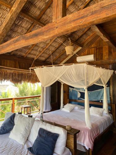 - une chambre avec 2 lits et un lit à baldaquin dans l'établissement Divino Tatajuba bungalows, Vista para o mar!, à Tatajuba
