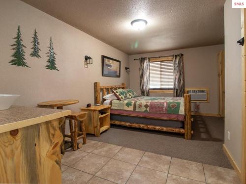 a bedroom with a bed in a room with trees at The Idaho Lodge & RV Park in Bonners Ferry