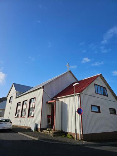a large white building with a car parked in front of it at Central Apartments in Vestmannaeyjar