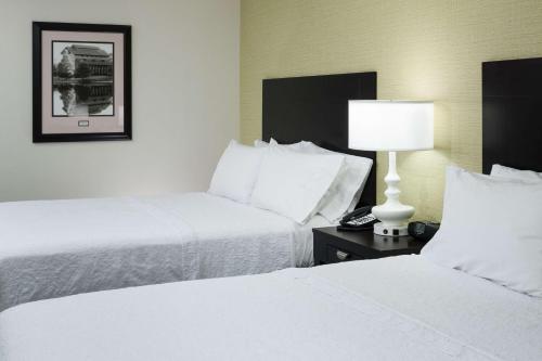 a hotel room with two beds and a lamp on a table at Hampton Inn & Suites Gainesville Downtown in Gainesville