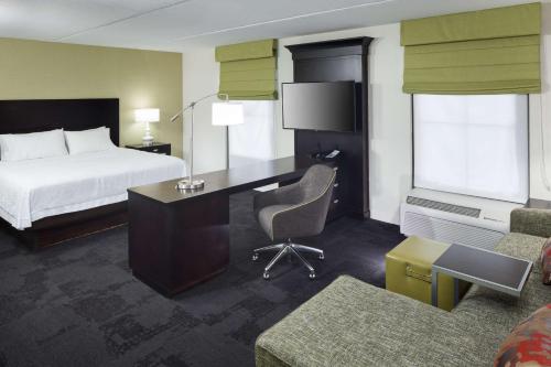 Habitación de hotel con cama, escritorio y cama en Hampton Inn & Suites Gainesville Downtown, en Gainesville