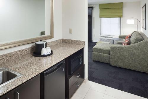 a kitchen and a living room with a couch at Hampton Inn & Suites Gainesville Downtown in Gainesville