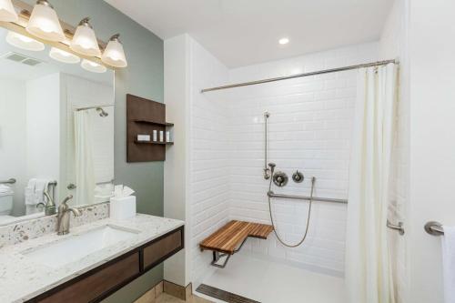 y baño blanco con bañera y ducha. en Hilton Garden Inn Davis Downtown, en Davis