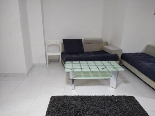 a living room with a couch and a coffee table at Studio Apartment in Ajman 