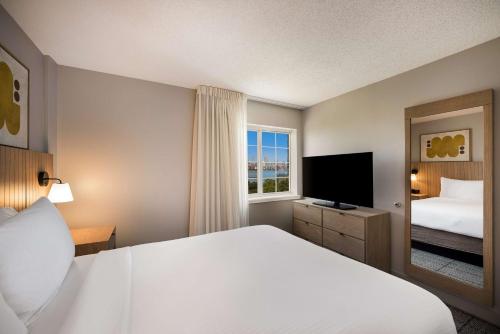 a hotel room with a bed and a television at Sonesta Simply Suites Jersey City in Jersey City