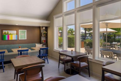 a restaurant with tables and chairs and windows at Sonesta ES Suites San Francisco Airport Oyster Point Waterfront in South San Francisco