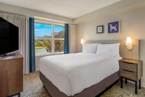 a bedroom with a large bed and a large window at Sonesta ES Suites San Francisco Airport Oyster Point Waterfront in South San Francisco