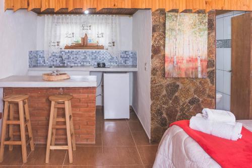 una cucina con bar e un letto in una camera di Chales Boa Vista a Monte Verde
