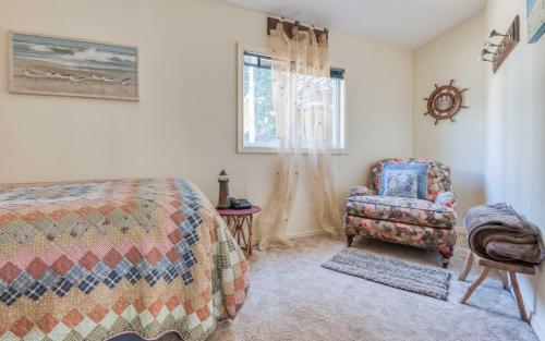 - une chambre avec un lit, une chaise et une fenêtre dans l'établissement Birds Eye Beach House, à Lincoln City