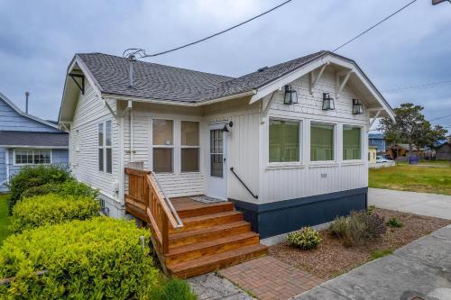 une maison blanche avec une terrasse couverte et des escaliers dans l'établissement Oasis By the Sea, à Seaside