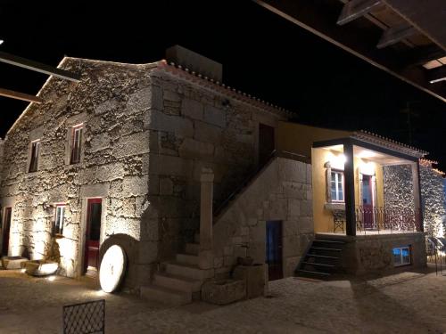 a stone building with a staircase in front of it at night at Solar de São João - Guest House - in Almeida