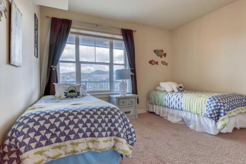 a bedroom with two beds and a window at River's Edge at Bridgeport in Seaside