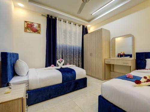 ENG-Murjan Apartment في العقبة: غرفة فندقية بسريرين ومرآة