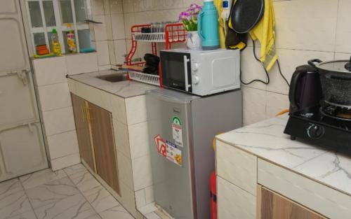 eine Küche mit einer Mikrowelle auf dem Kühlschrank in der Unterkunft Poly's Place Airbnb in Nairobi