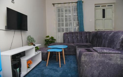 ein Wohnzimmer mit einem Sofa und einem Tisch in der Unterkunft Poly's Place Airbnb in Nairobi