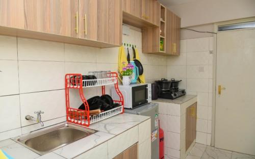 eine Küche mit einem Waschbecken und einem roten Korb auf der Theke in der Unterkunft Poly's Place Airbnb in Nairobi