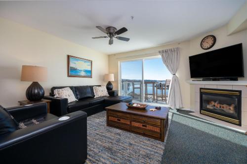 a living room with a couch and a tv and a fireplace at Waters Edge 404 in Lincoln City