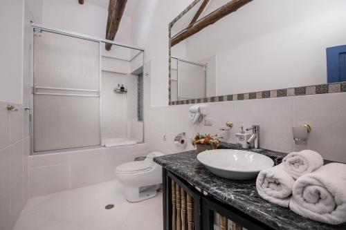 a white bathroom with a sink and a toilet at Inkarri Regocijo Plaza in Cusco