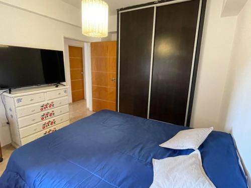 a bedroom with a blue bed and a television at Liban 1 in San Juan