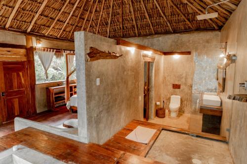 une salle de bain avec douche et toilettes dans une chambre dans l'établissement Aldea Colibri, à Macario Gomez