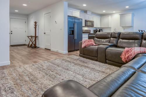 a living room with a leather couch and a kitchen at Hideaway in Seaside in Seaside