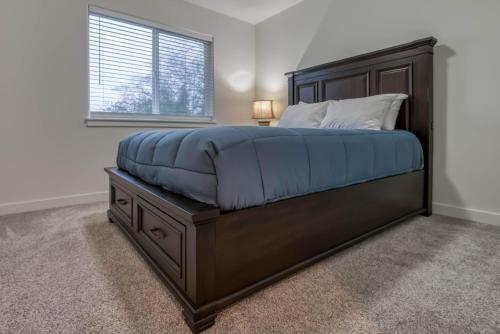 a bedroom with a large bed with blue sheets and a window at Hideaway in Seaside in Seaside