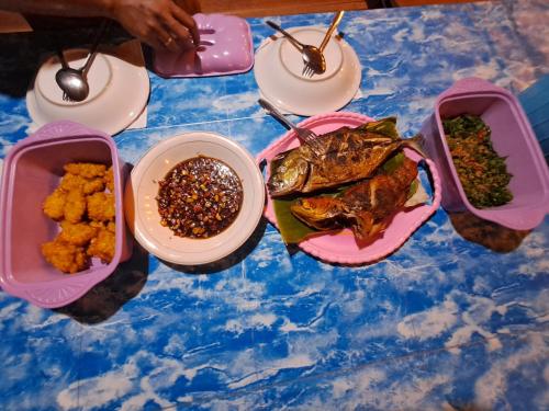 GAM BAY bungalow's في بصير: طاولة مع أطباق من الطعام وأوعية من الطعام