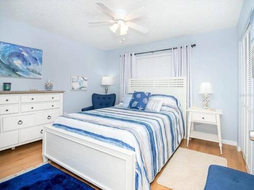 a white bedroom with a bed and a ceiling fan at Charming Vintage Haven in Tarpon Springs
