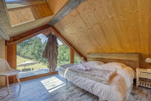 a bedroom with a bed and a large window at Le Chalet des Eaux - Thermes - Ski in Revel