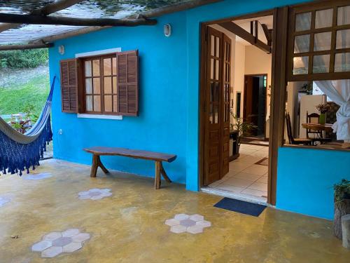 uma casa azul com um banco à frente de uma porta em Vila Verde Perto em Lençóis