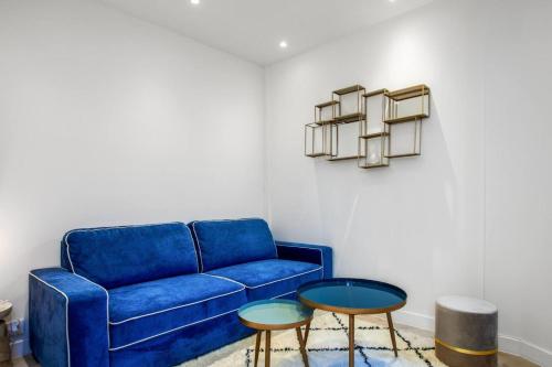 un salon avec un canapé bleu et deux tables dans l'établissement Cozy apartment near the beach, à Antibes
