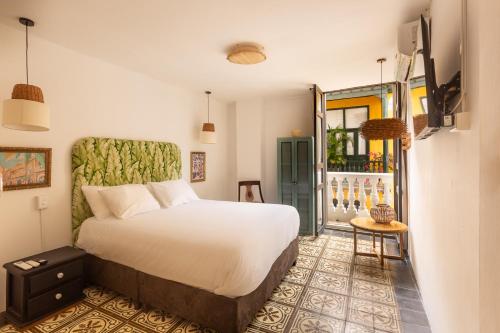 Un dormitorio con una gran cama blanca y una mesa en Al Alma Apart-Suites, en Cartagena de Indias