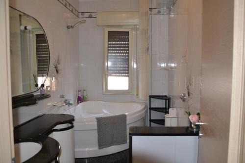 a white bathroom with a tub and a sink at Terrazza sul Mare Vecchio Pontile in Gela