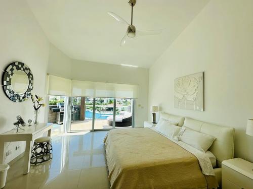 1 dormitorio blanco con 1 cama grande y espejo en Luxury Beachfront Resort at MAREAZUL en Playa del Carmen