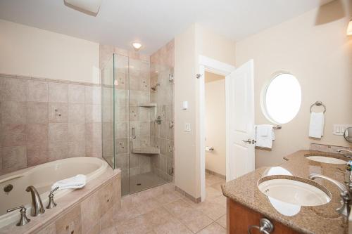 a bathroom with a tub and two sinks and a shower at Michael's Beach Place @ Shoreline Ridge in Newport