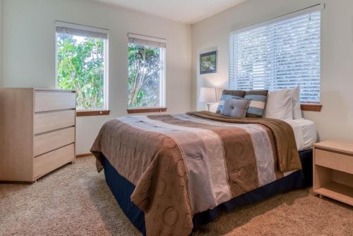 a bedroom with a bed and a dresser and two windows at The Lookout in Newport