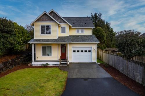 a yellow house with a white garage at Necanicum House in Seaside