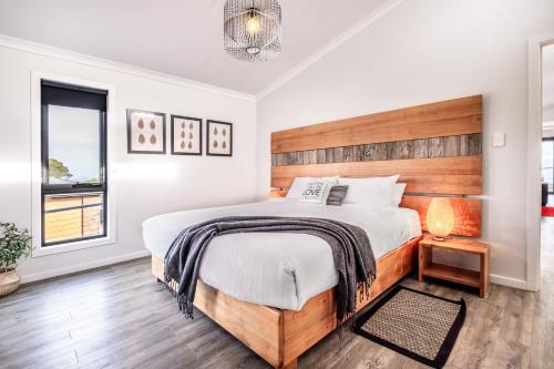 um quarto com uma cama grande e uma cabeceira em madeira em Whale Watcher 1 em Coles Bay