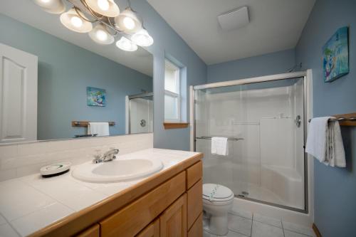 a bathroom with a sink and a glass shower at Necanicum House in Seaside